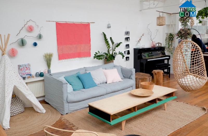 Màu hồng và xanh pastel thêm sức sống cho không gian phòng khách Scandinavia có tường trắng và sàn gỗ màu nâu trung tính.